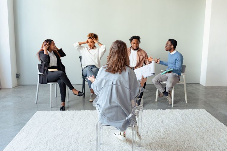 Grupo de pessoas participa de uma conversa sobre saúde mental em ambiente interno.