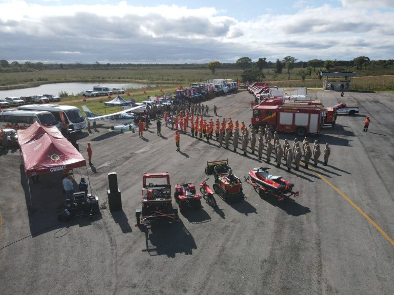 Vista aérea de equipes e equipamentos de bombeiros durante um treinamento de defesa civil.